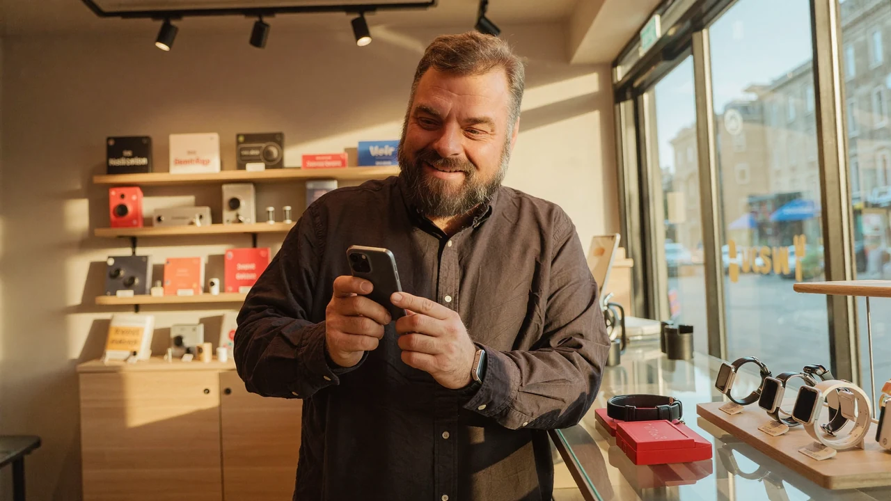 Christian Rill im greem-Shop an der Theke, daneben eine Auslage mit Smartwatches