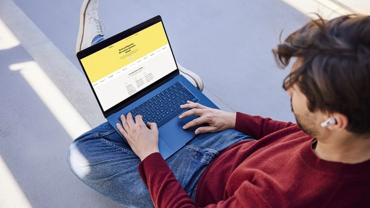 Person nutzt draußen am Laptop die Werkstattsuche der Reparaturplattform